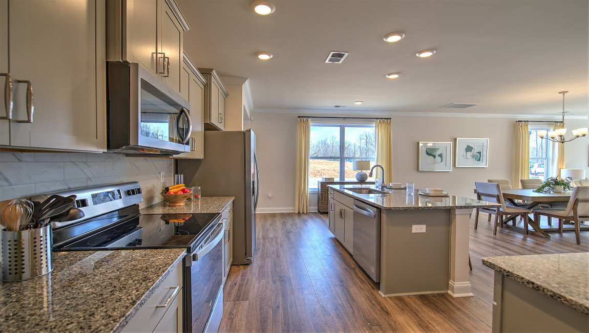 Kitchen and island with grey cabinets and stainless steel appliances
