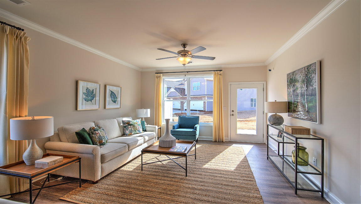 Living room beside kitchen with large windows and back door