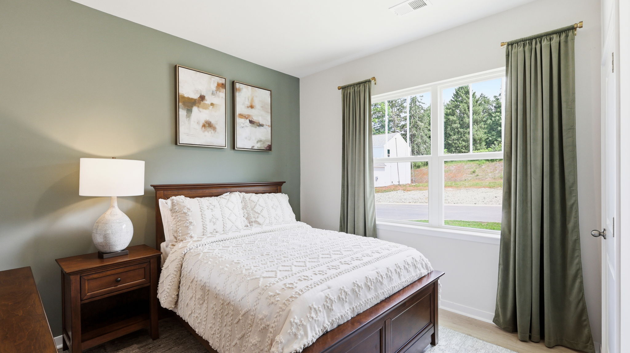 Carpeted bedroom with large windows and green accent wall