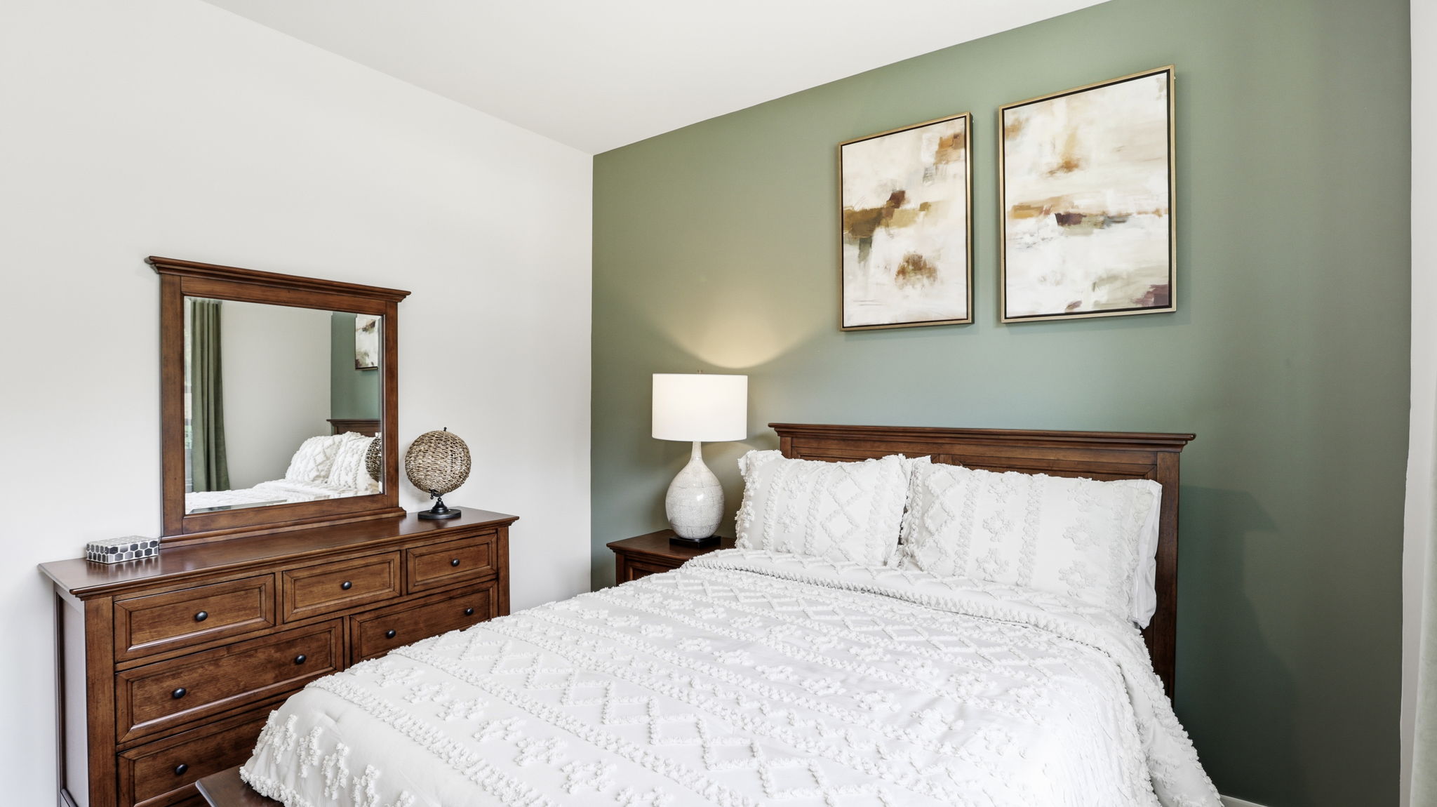 Carpeted bedroom with large windows and green accent wall