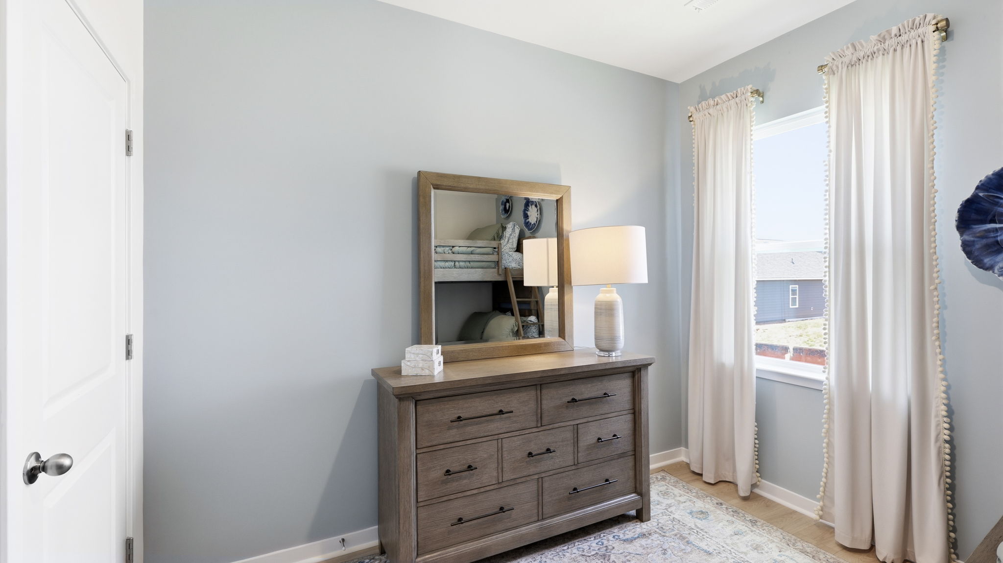 Carpeted bedroom with large window and light blue accent wall