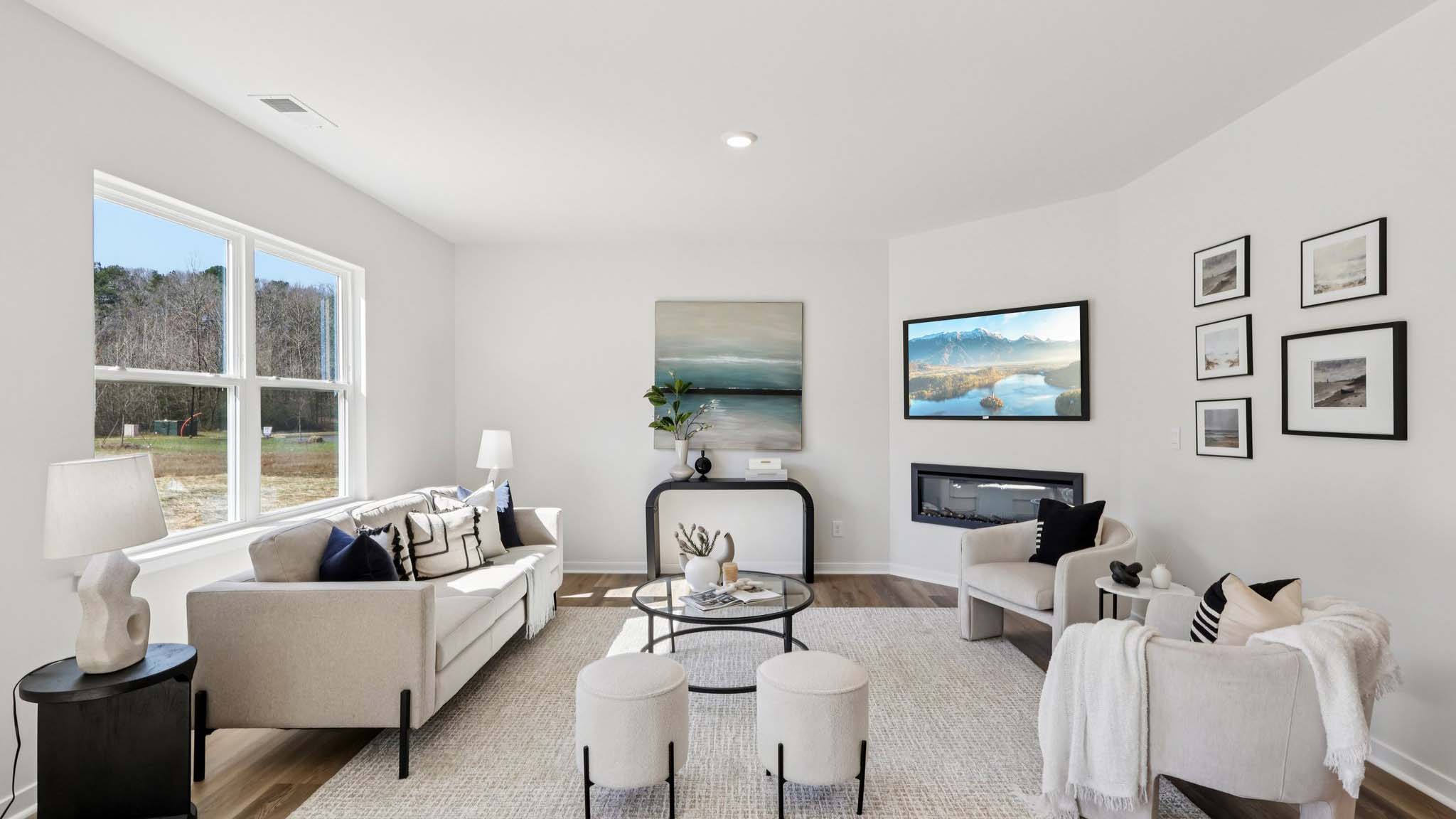 Open concept living area with large window and electric fireplace