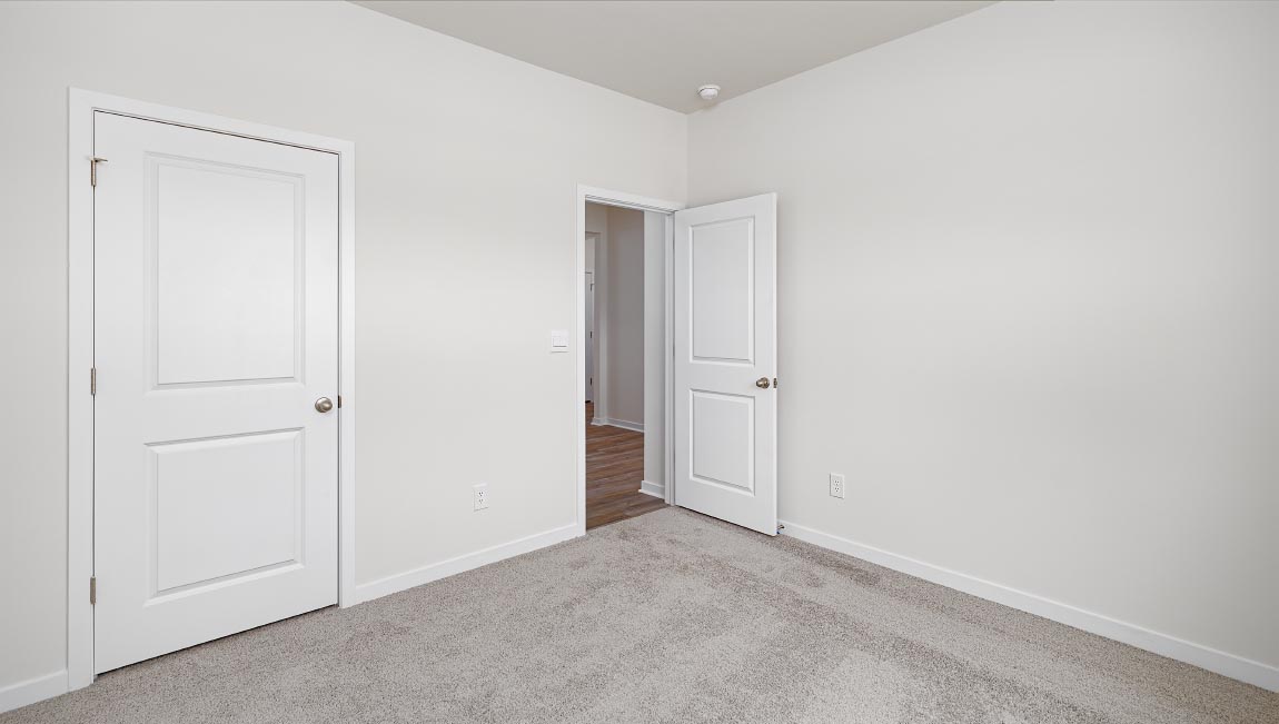 Carpeted bedroom with large windows