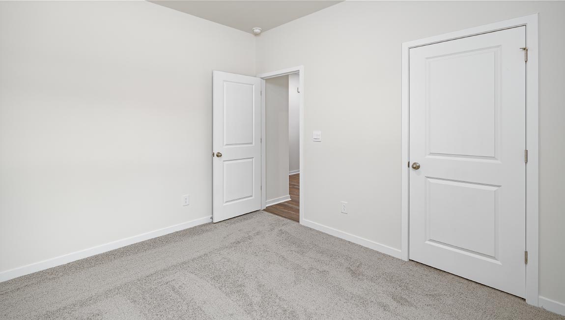 Carpeted bedroom with large windows
