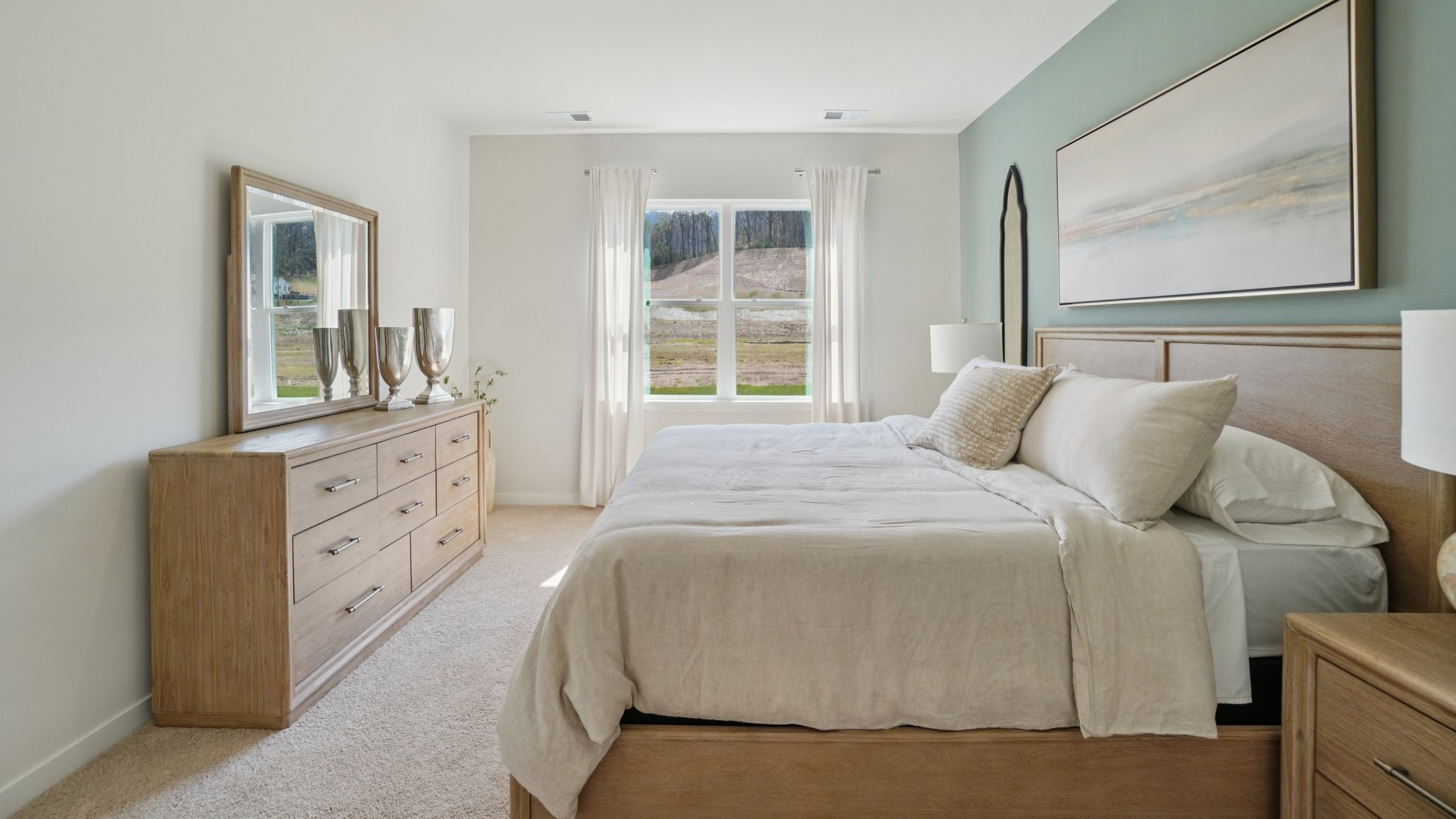 Carpeted primary bedroom with large windows