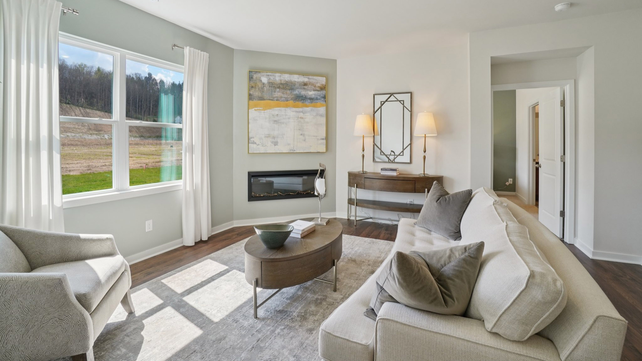 Open concept living area with electric fireplace and large windows