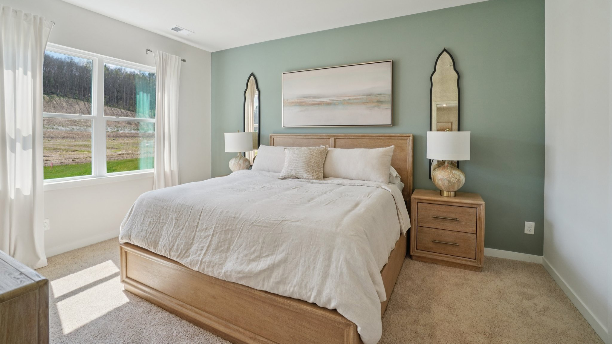 Carpeted primary bedroom with large window