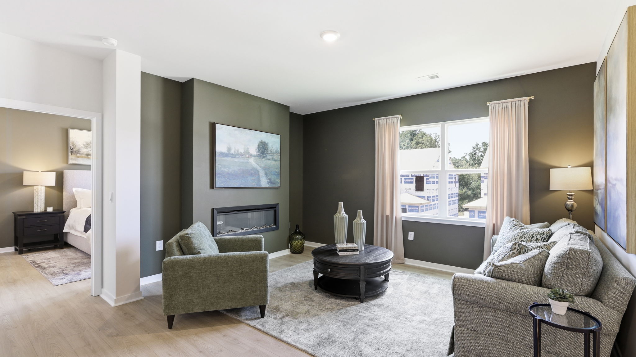 Open living area with large windows and electric fireplace