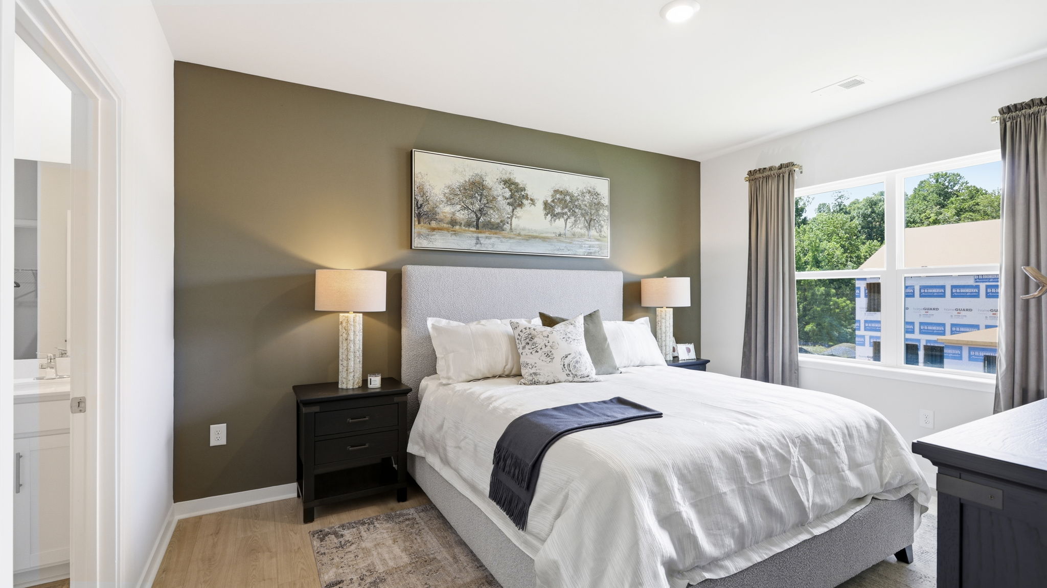 Primary bedroom with large windows and ensuite bathroom