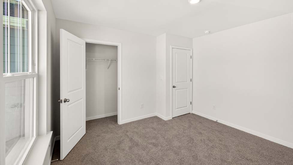 Carpeted bedroom with closet