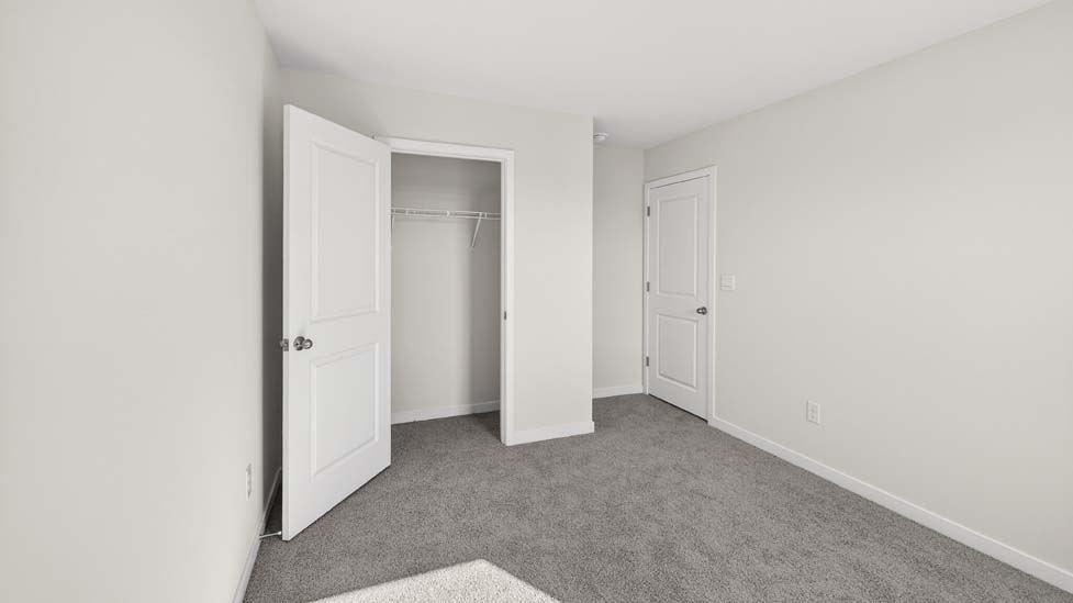 Carpeted bedroom with closet