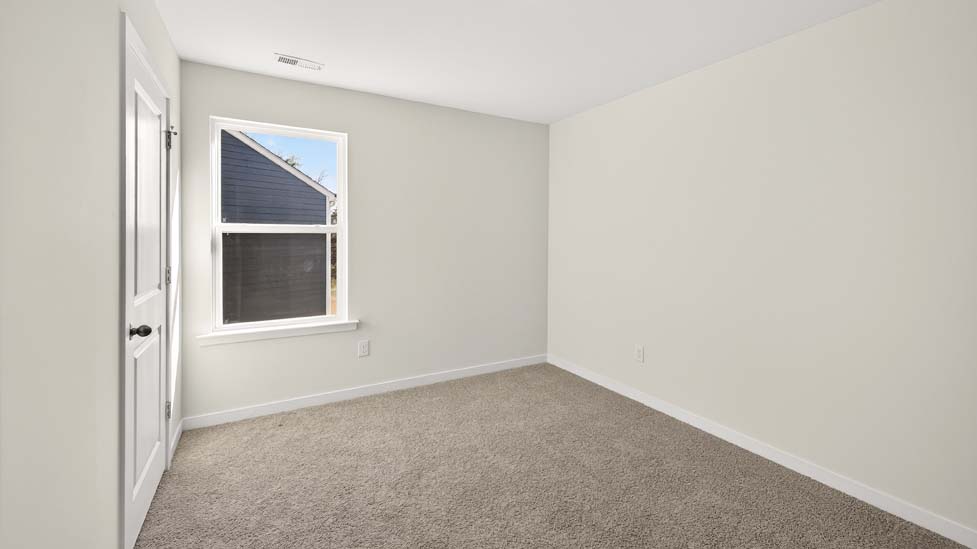 Carpeted bedroom with large windows