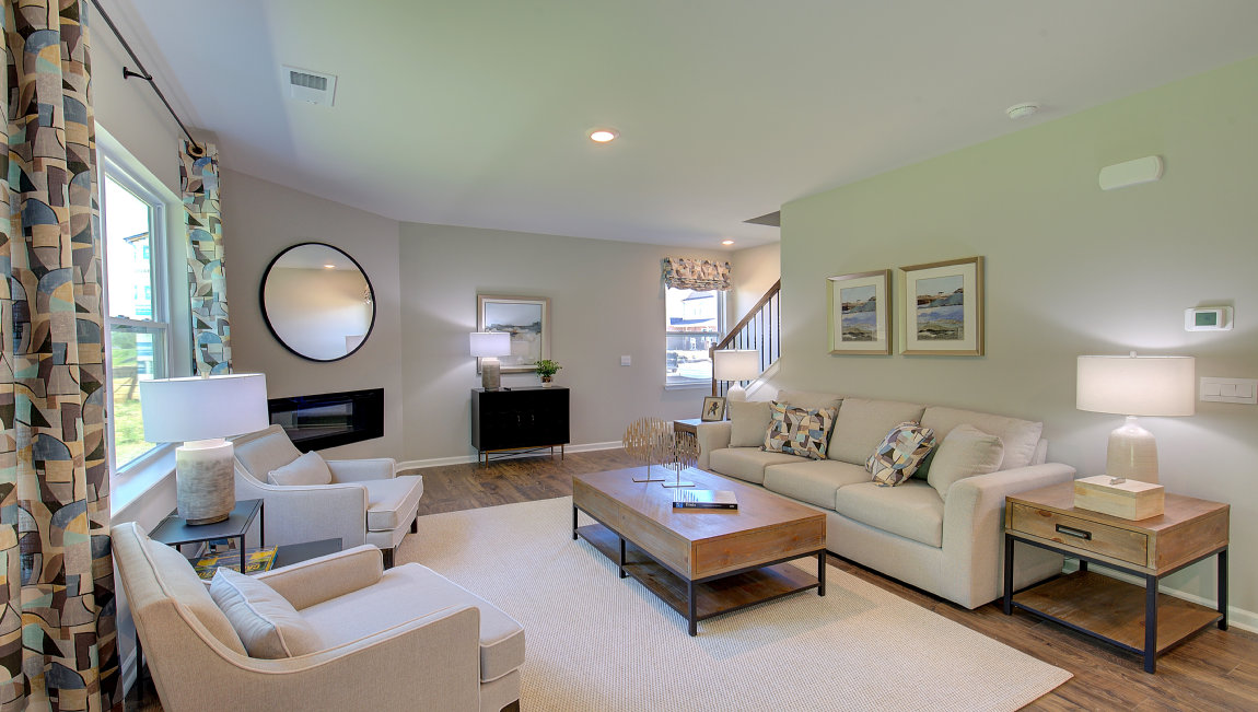 Open living area with electric fireplace and large windows