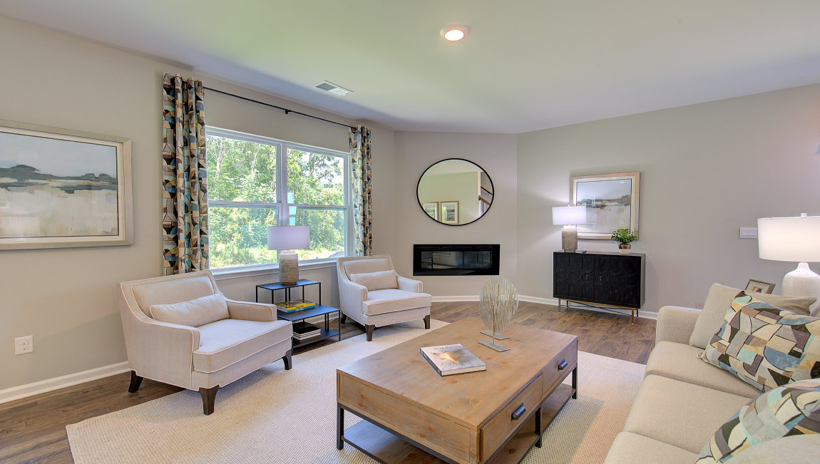 Open living area with electric fireplace and large windows