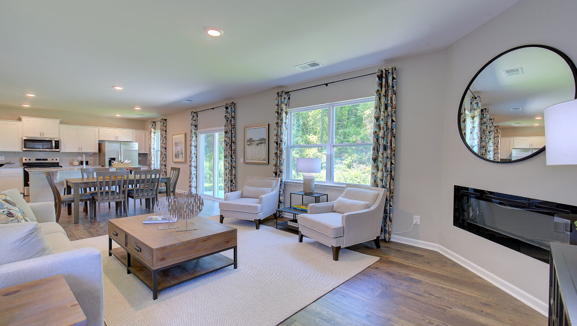 Open living area with electric fireplace and large windows