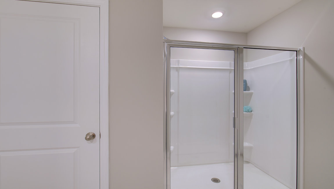 Primary bathroom with dual vanity and walk in shower with glass doors