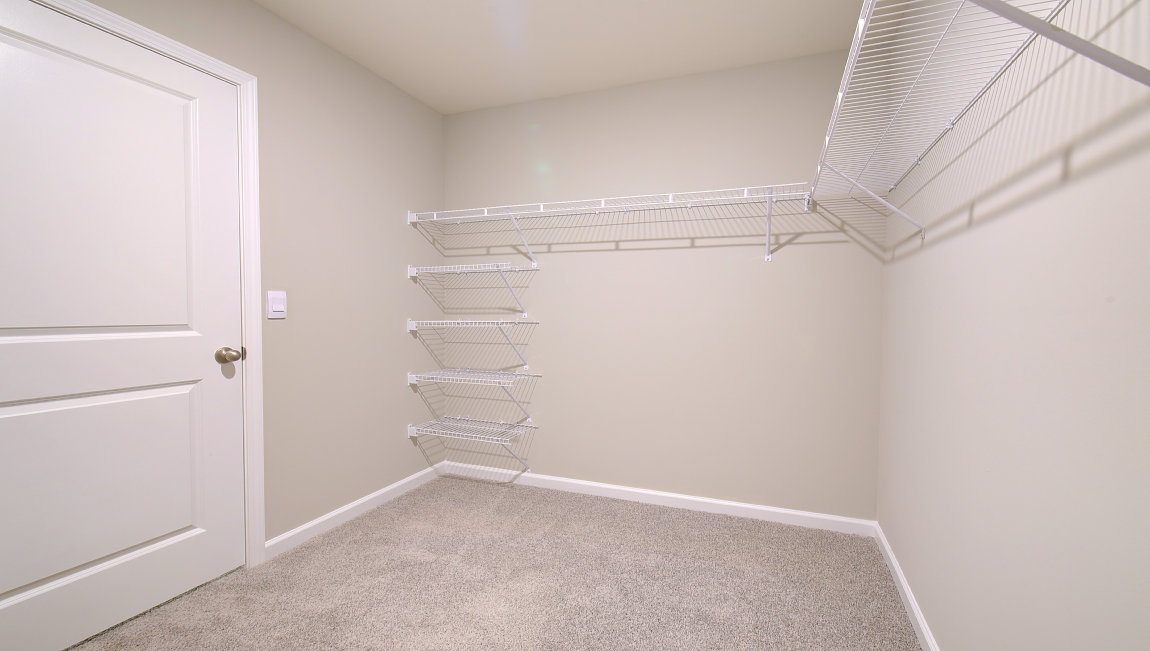 Primary walk in closet with shelving