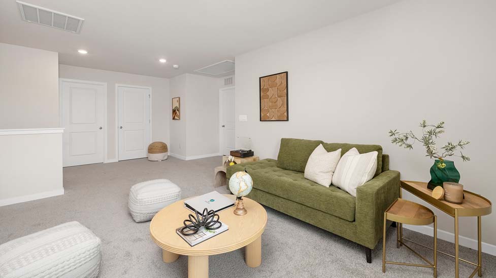 Carpeted open loft area with windows
