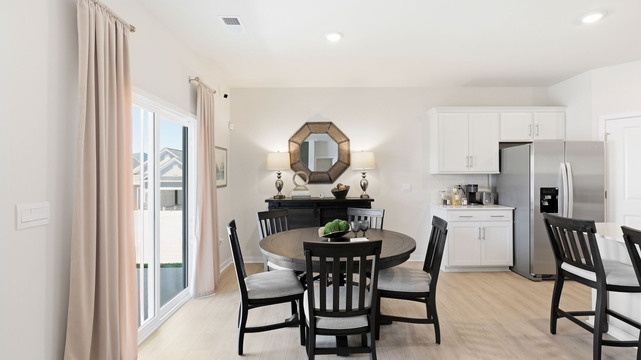 Open dining area with view of kitchen and sliding glass doors to back patio
