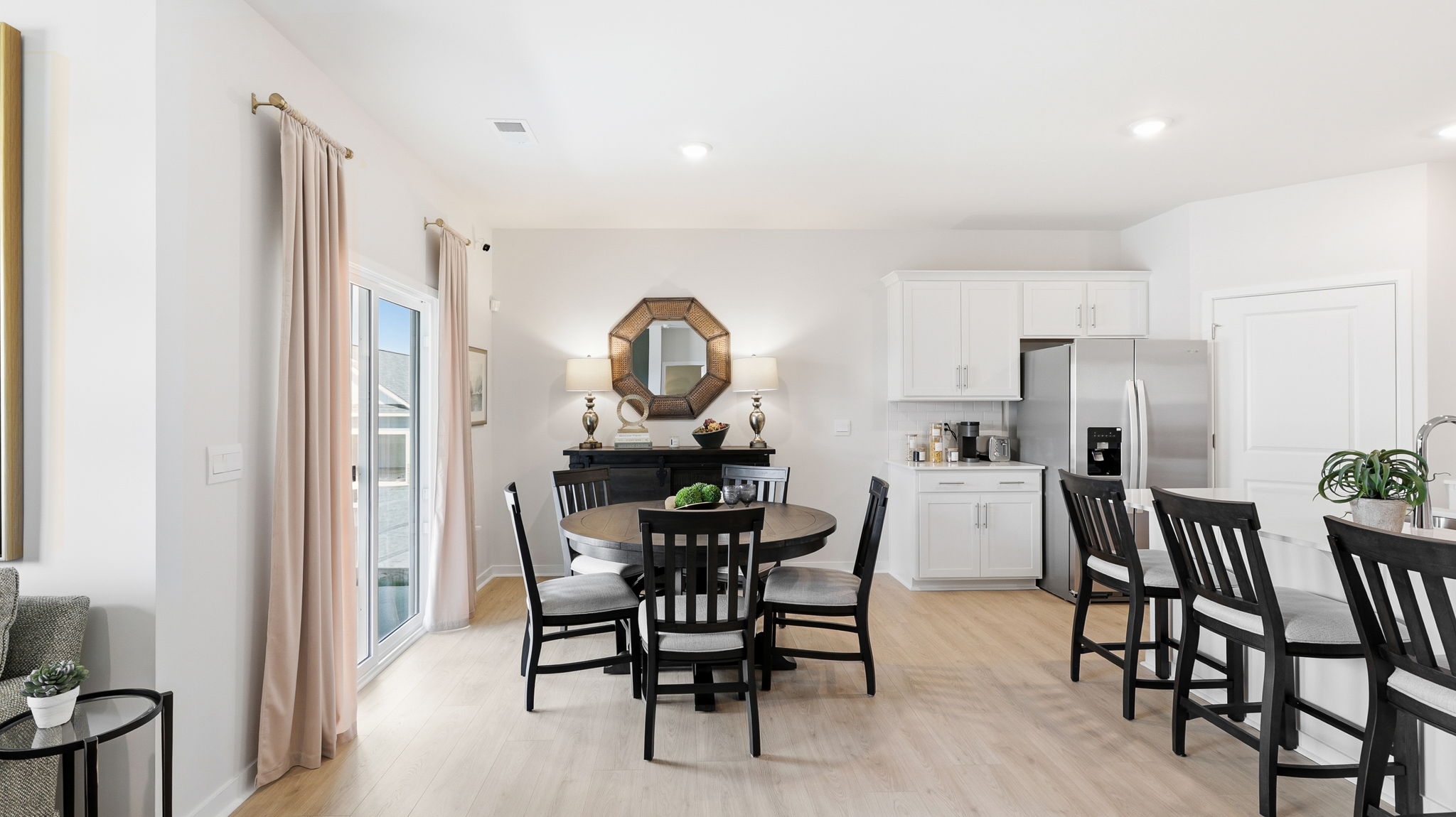 Open dining area with view of kitchen and sliding glass doors to back patio