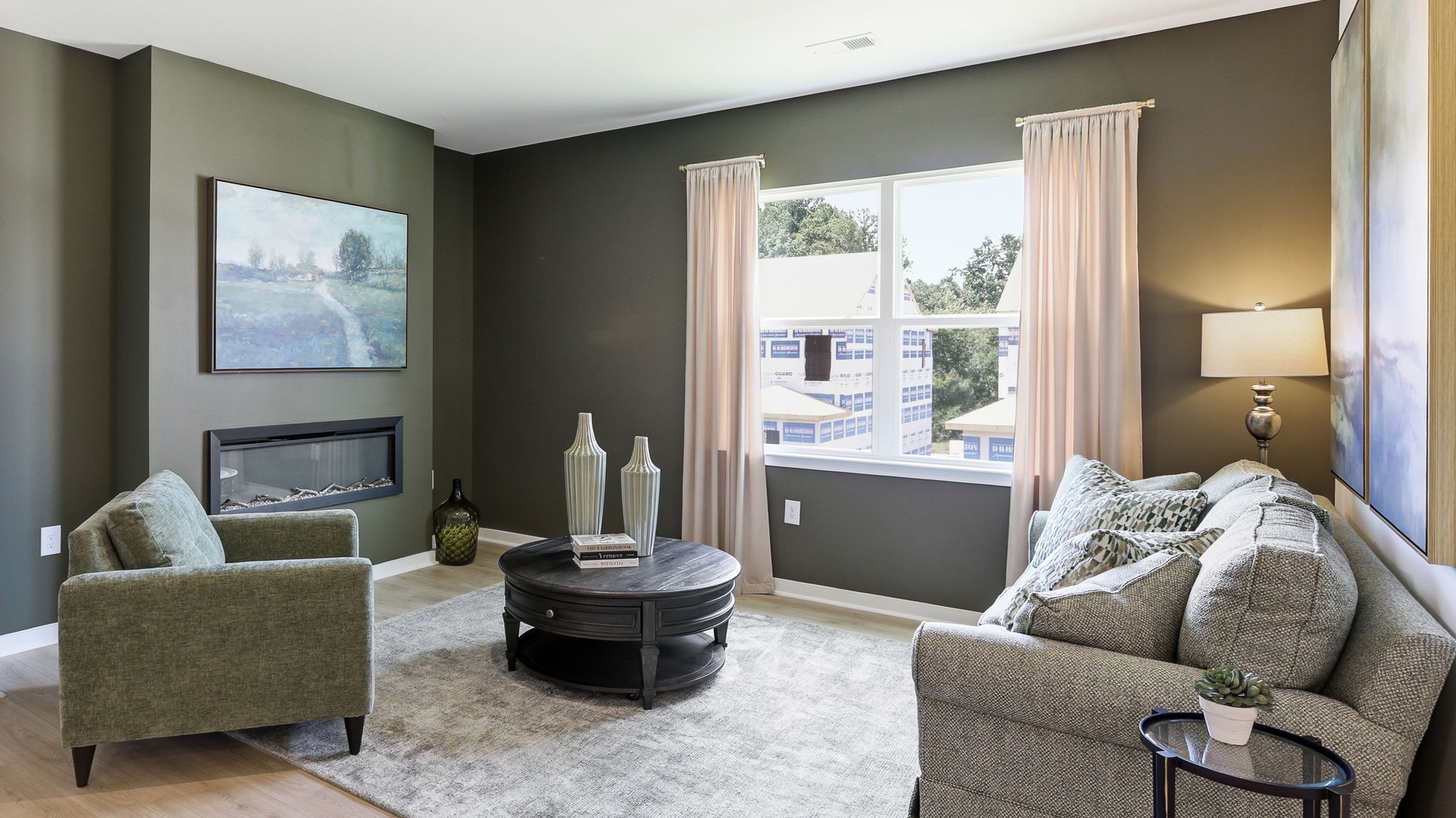 Open concept living area with large windows and electric fireplace