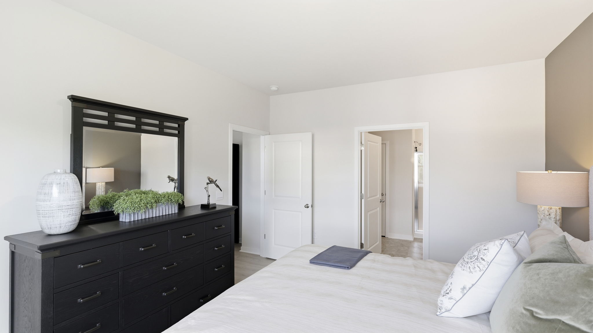 Carpeted primary bedroom with views of bathroom