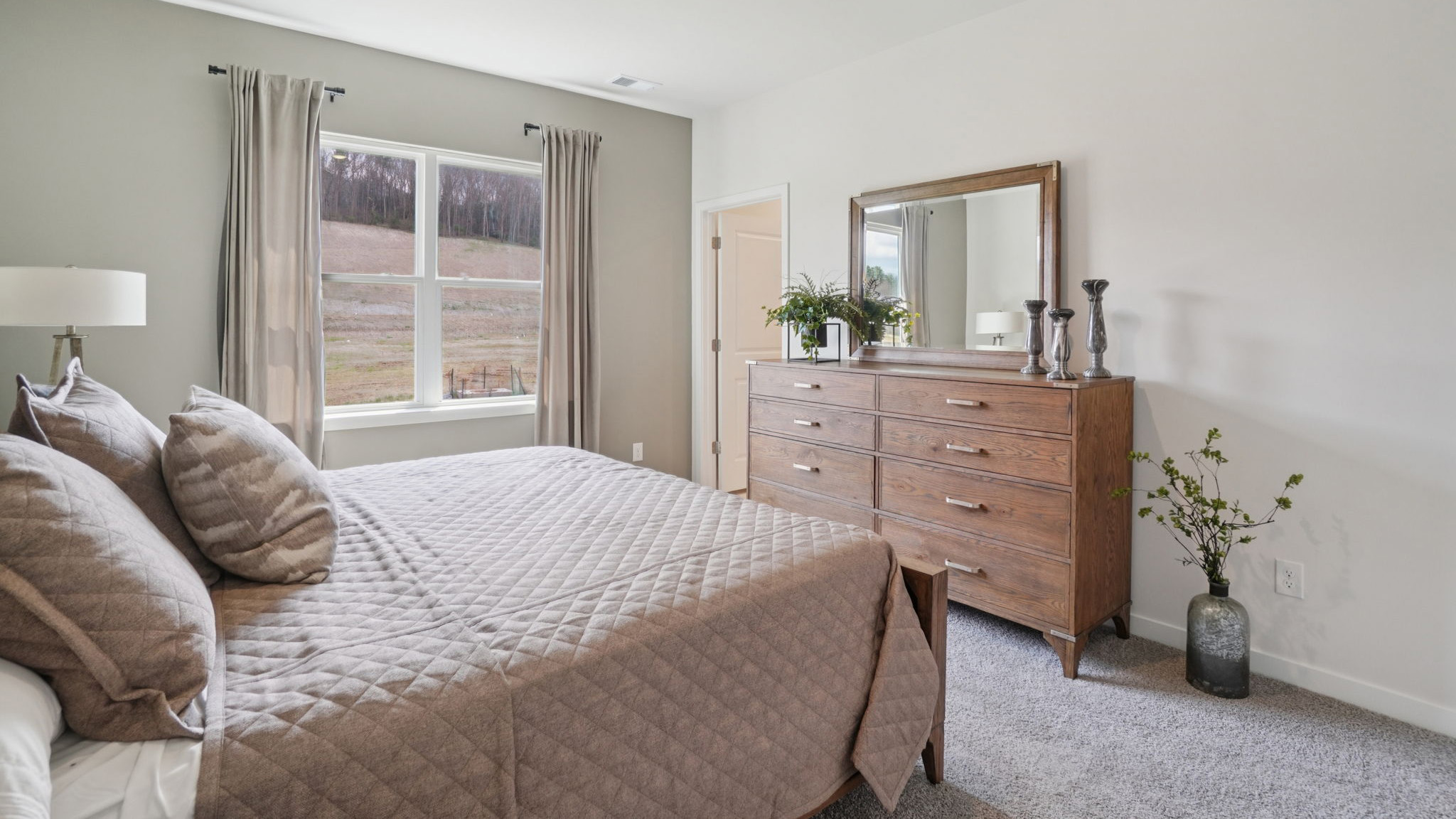 Carpeted primary bedroom with large windows