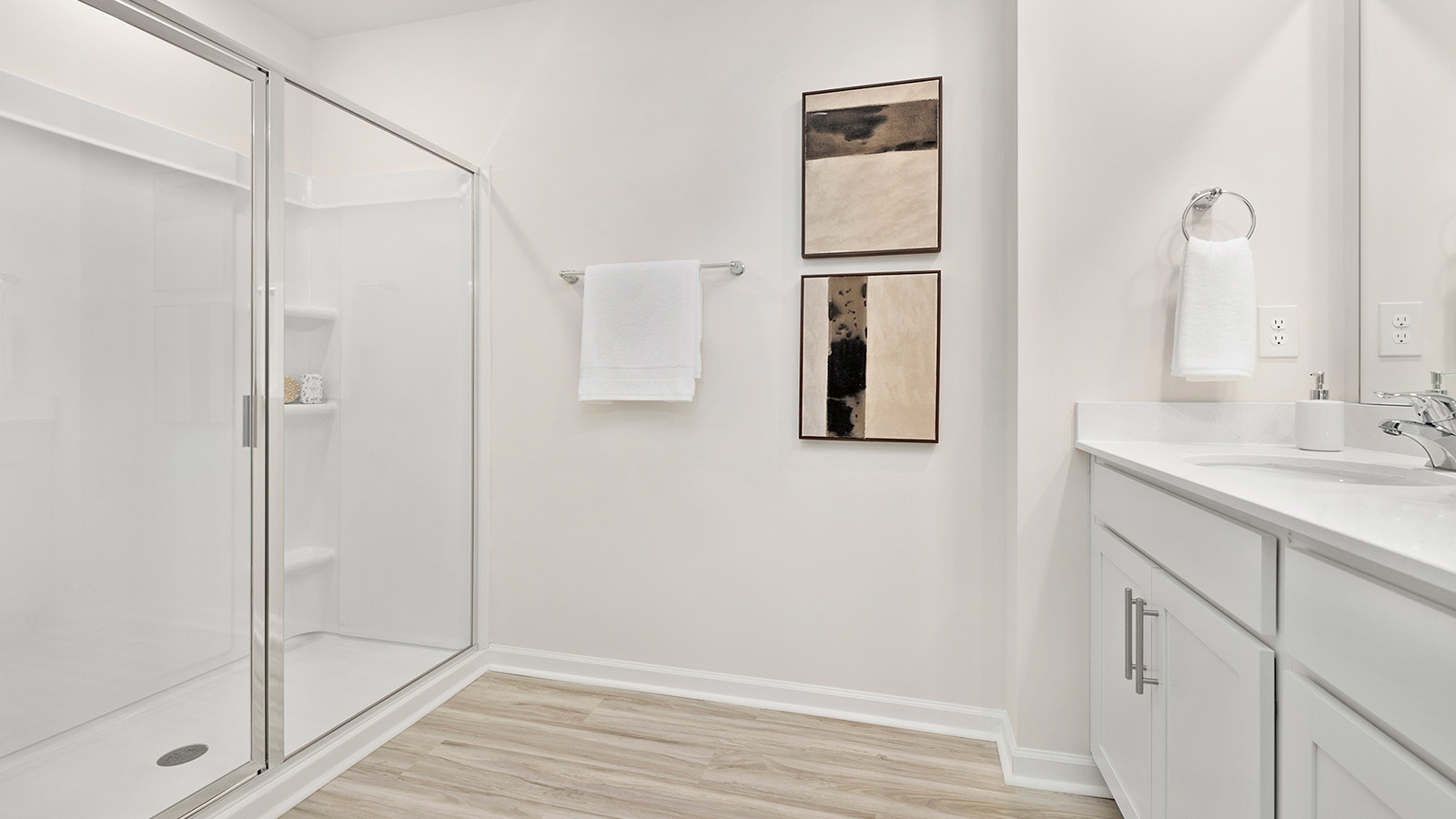 Primary bathroom with dual vanity and walk in shower with glass doors