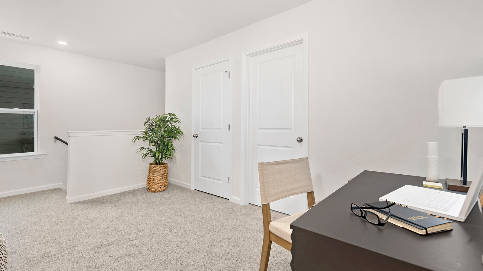 Carpeted loft area with large window
