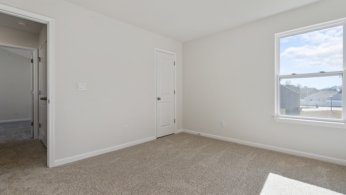 Carpeted bedroom with small window