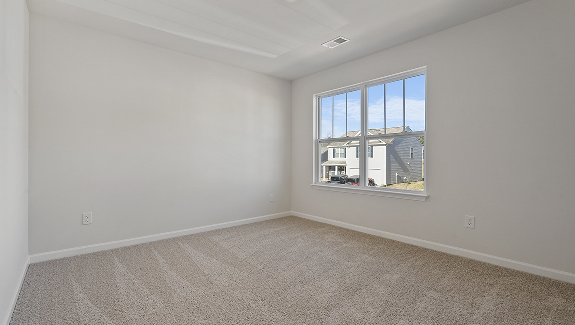 Carpeted bedroom with small window
