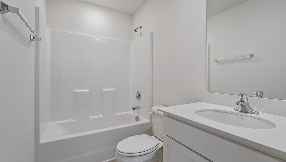Bathroom with white sink and cabinets, with a bathtub