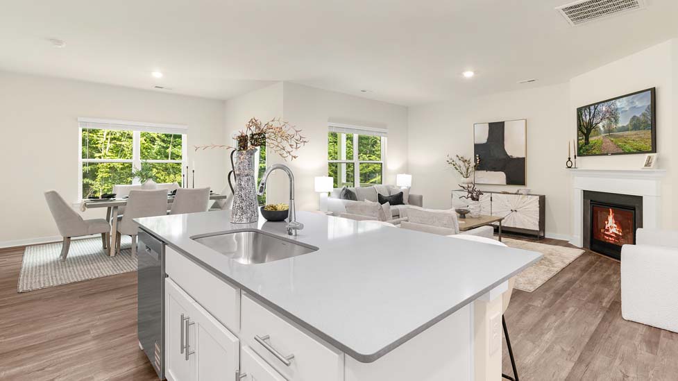 Kitchen and island with white cabinets, quarts countertops, wood floors, and stainless steel appliances