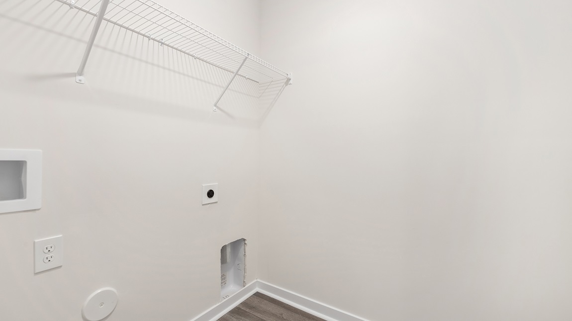 Laundry room with built in storage and hanging racks above machine space