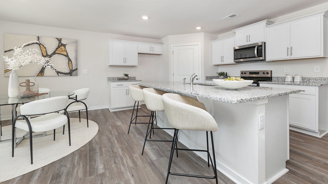 Kitchen and island with white cabinets and subway tiles and stainless steel subway tiles