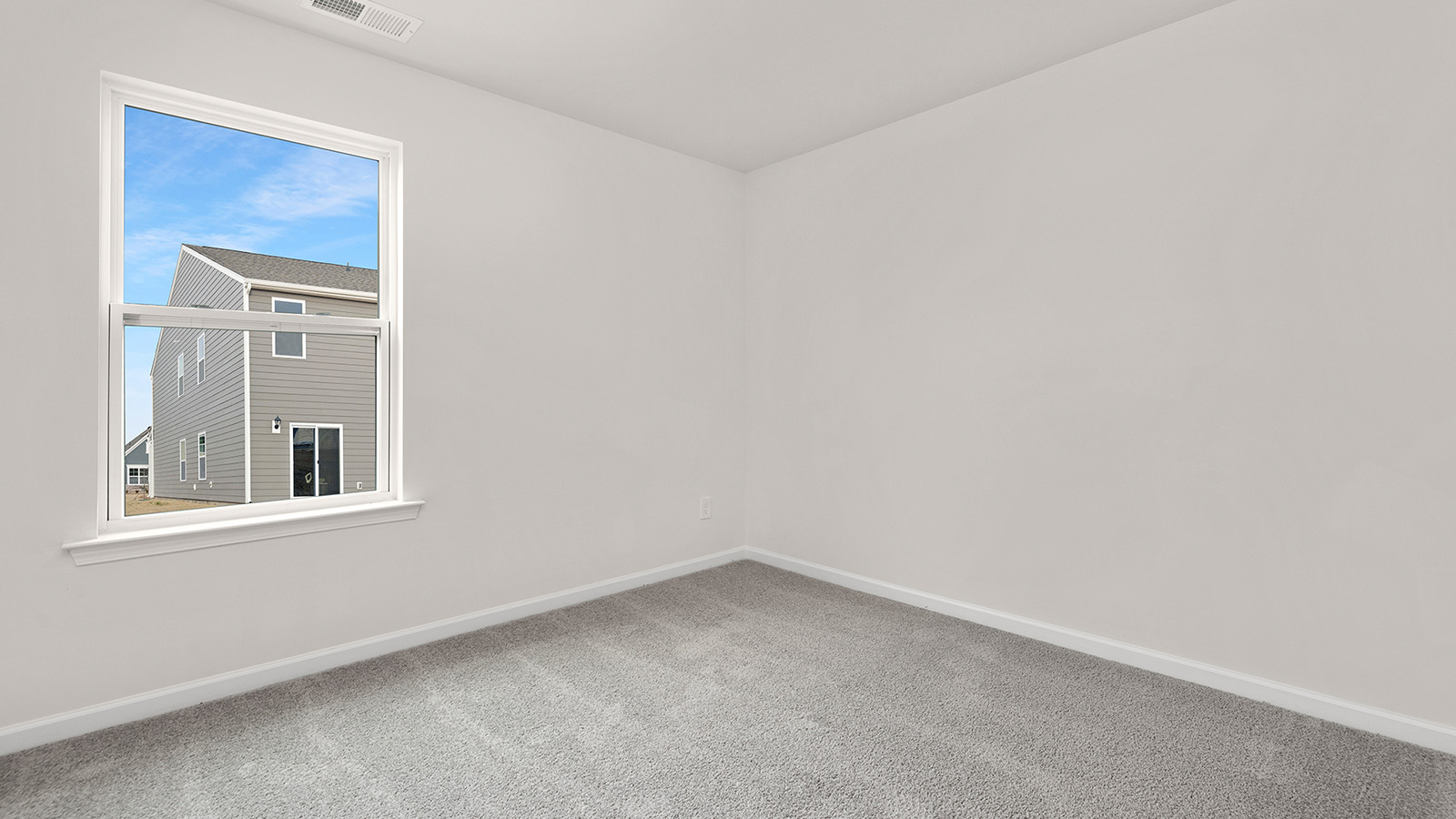 carpeted bedroom with small window and closet