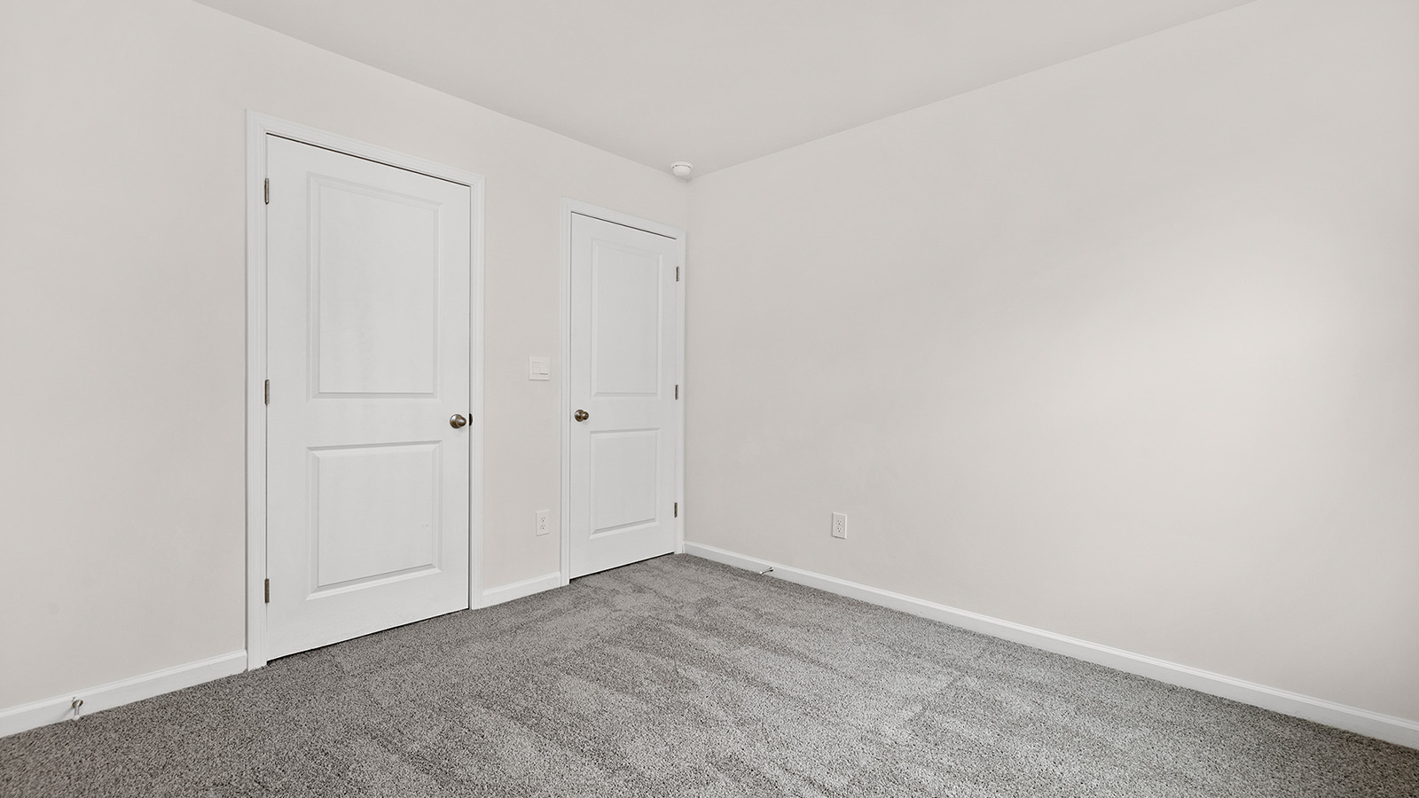 carpeted bedroom with small window and closet