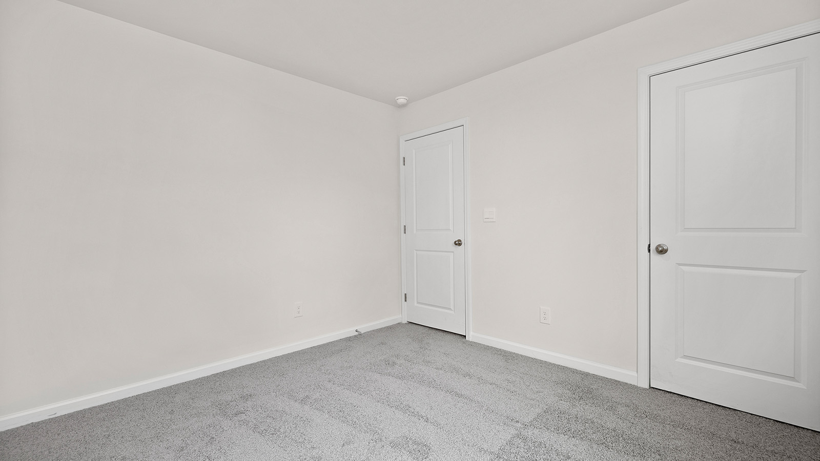 carpeted bedroom with small window and closet