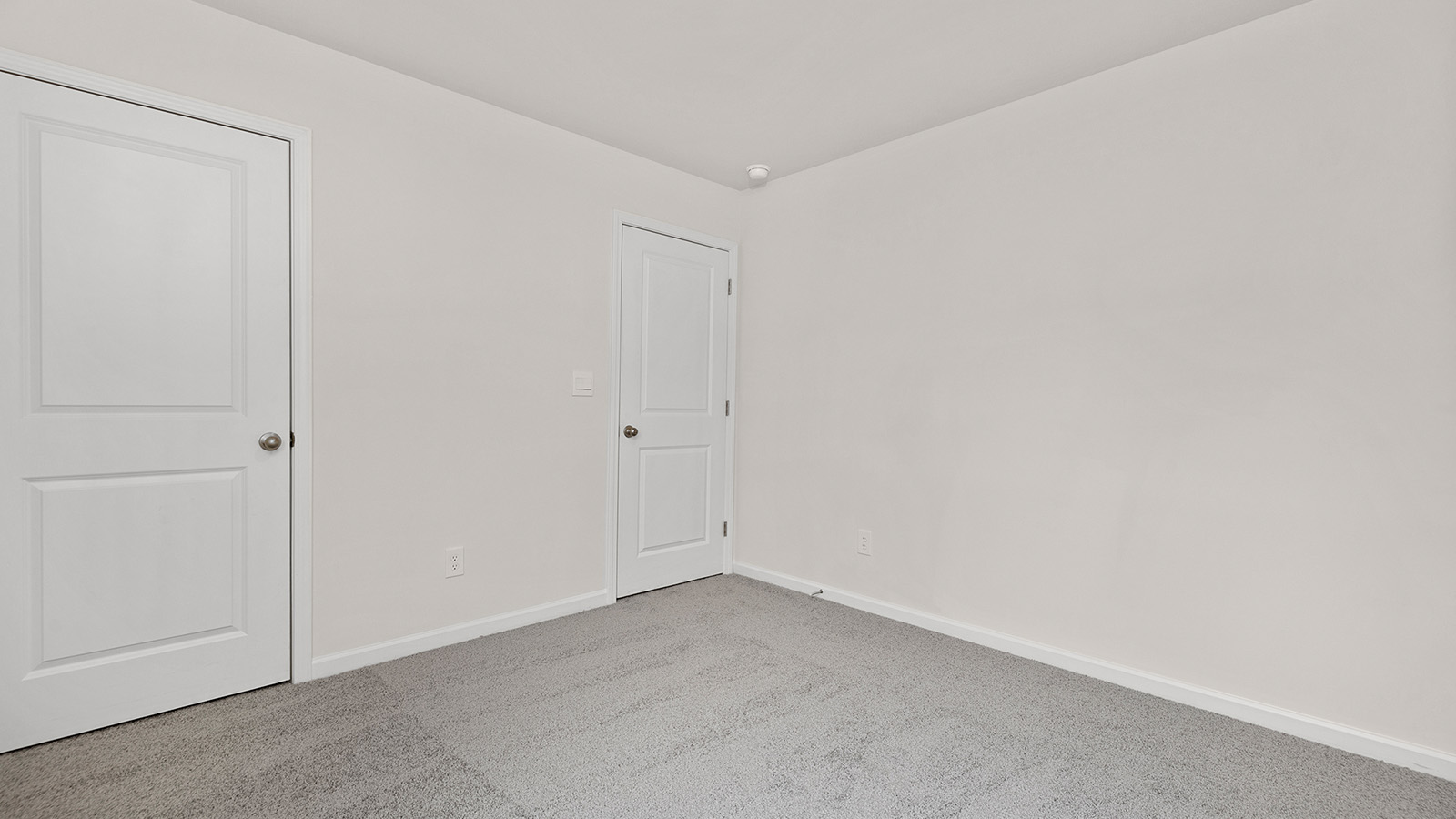 carpeted bedroom with small window and closet
