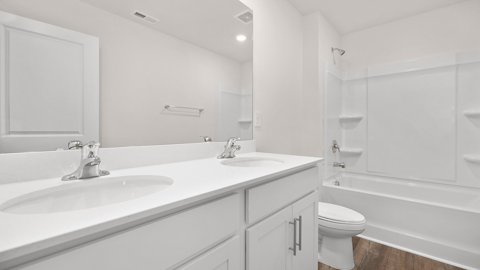 Bathroom with double sink vanity, white cabinets and bathtub shower combination