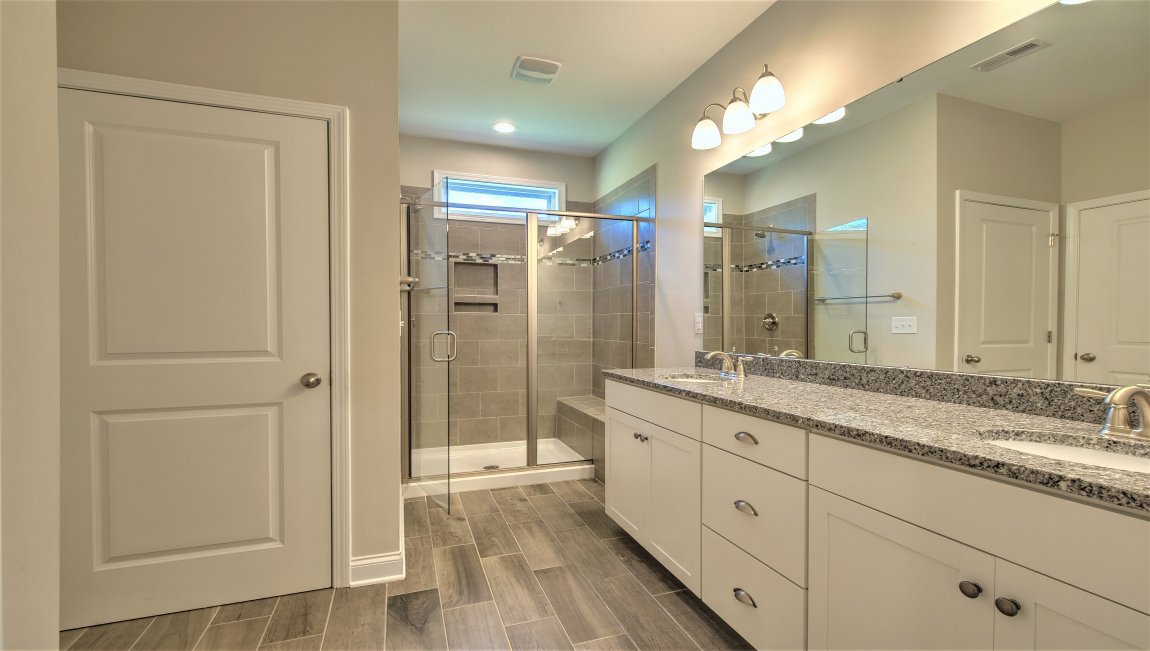 Primary bathroom with double vanity and walk in shower