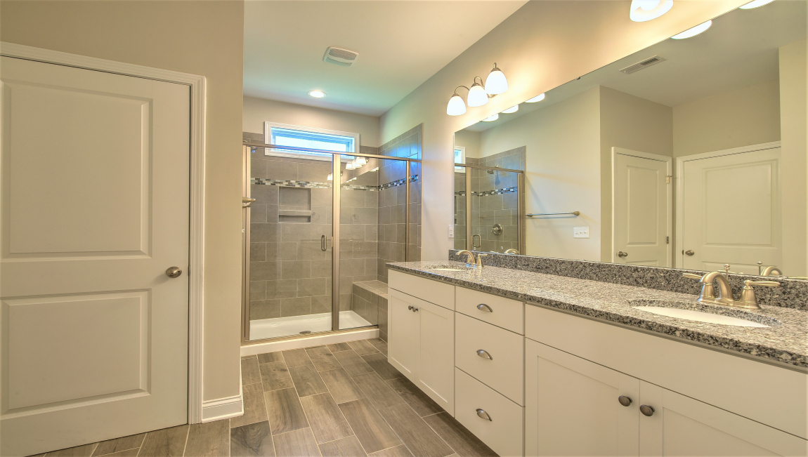 Primary bathroom with double vanity and walk in shower
