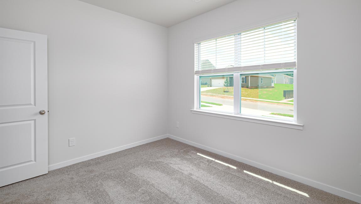 Carpeted bedroom with large window