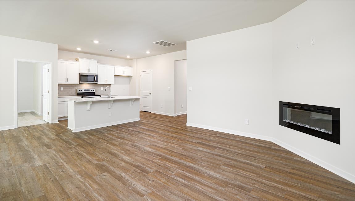 Kitchen and island with white cabinets, quarts countertops, wood floors, and stainless steel appliances