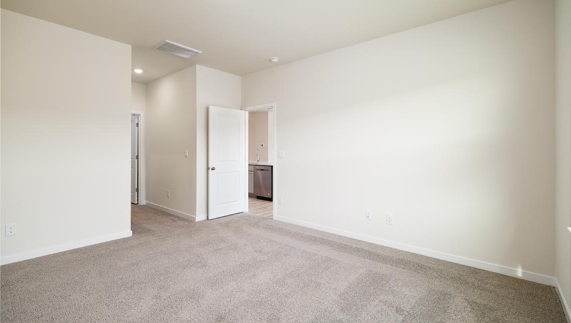 Carpeted bedroom with view of bathroom