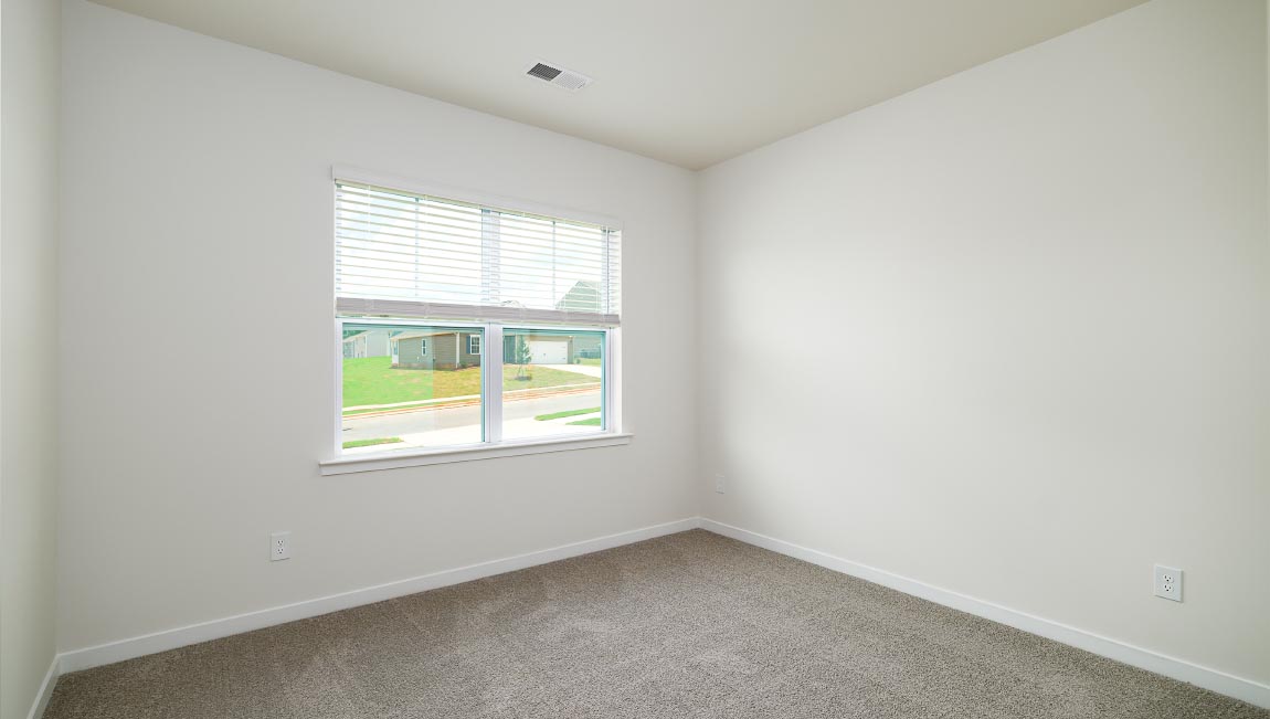 Carpeted bedroom with large windows