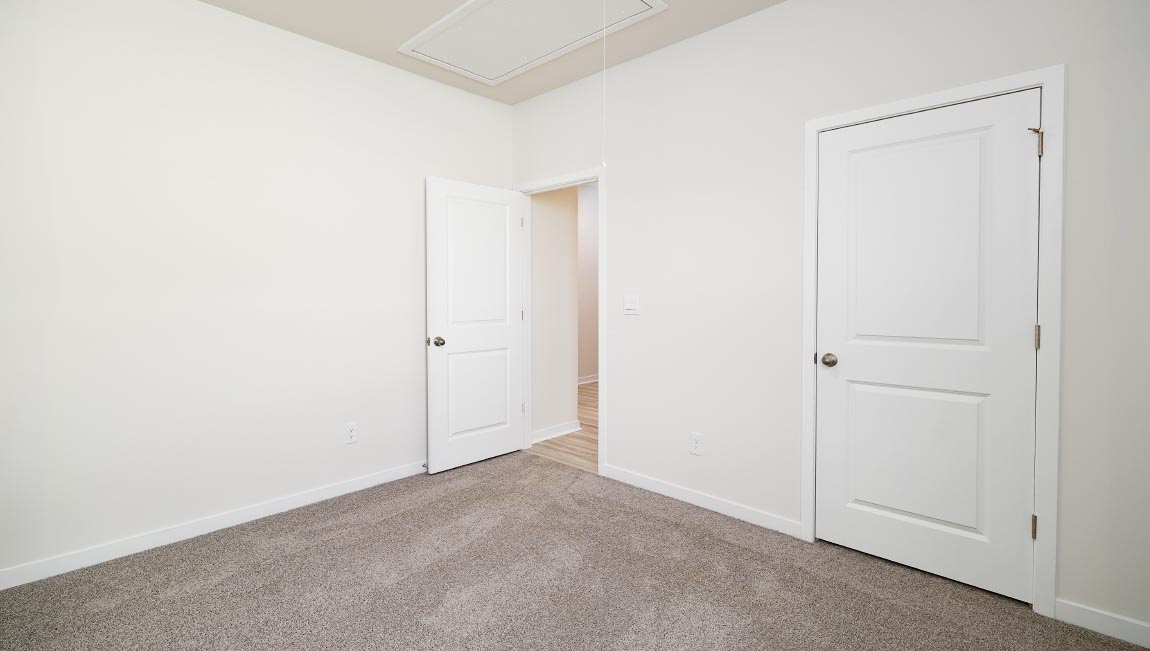 Carpeted bedroom with closet