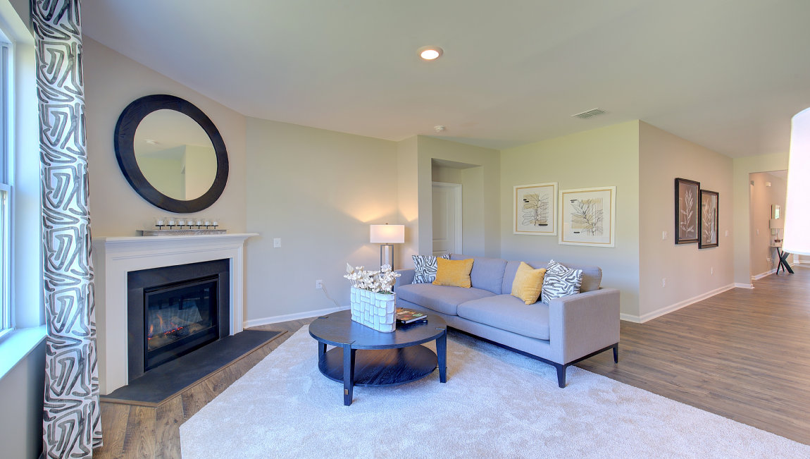 Open living room with wood floors, large window, and fireplace