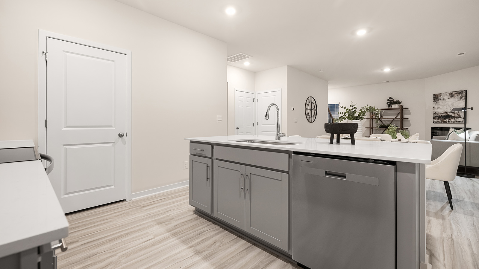 kitchen and island with white cabinets, wood floors and stainless steel appliances