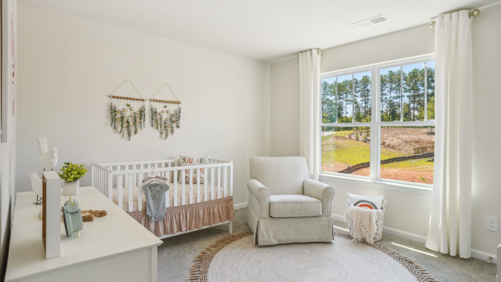 Model carpeted bedroom with large window